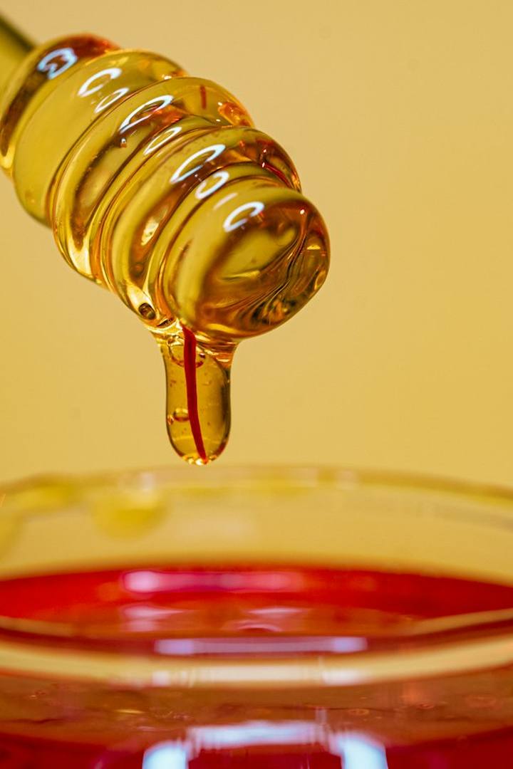 Honey pouring into a jar