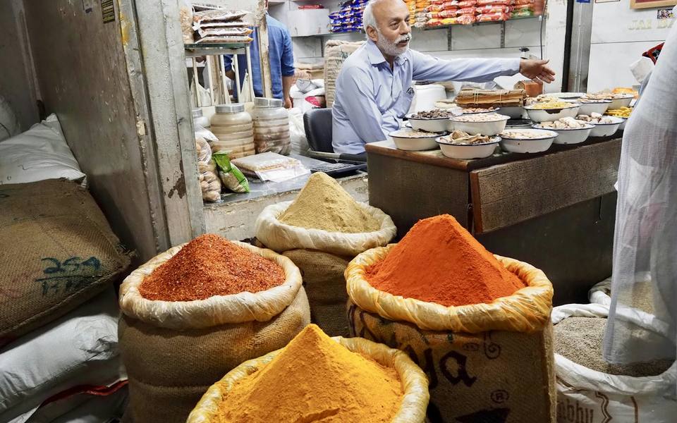 A vendor at his stall with sacks of spices